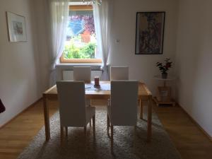 uma mesa de jantar com cadeiras e uma janela em MILLIEs hosting - Familienurlaub mit Hund in Kärnten em Sankt Paul im Lavanttal
