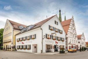un grande edificio bianco su una strada con chiesa di Fuchsbräu a Beilngries