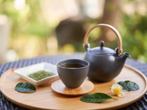a cup of tea and a tea pot on a wooden tray at Yukai Resort Premium Awazu Grand Hotel in Komatsu