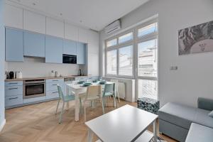a kitchen and living room with a table and chairs at Lion Apartments - Nicea in Sopot