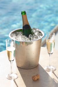 a bottle of champagne in an ice bucket next to two glasses at Premier Splendid Inn Bayshore in Richards Bay