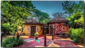 una pequeña casa con un rojo y amarillo en Mandore Guest House, en Jodhpur