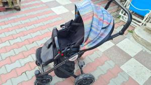 a baby stroller with a blanket on a sidewalk at Casa Arina in Sulina