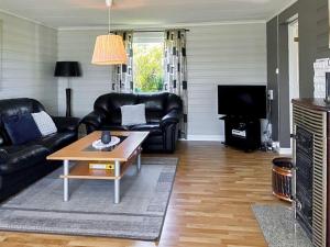 a living room with black leather furniture and a coffee table at Five-Bedroom Holiday home in Vevang 1 in Vevang