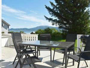 a table and chairs on a patio with a view of the water at Five-Bedroom Holiday home in Vevang 1 in Vevang