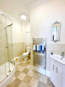 a bathroom with a shower toilet and a sink at Stylish apartment with free parking, lift & views in Scarborough