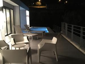 une terrasse avec des chaises et une piscine ouverte la nuit dans l'établissement Villa 5* Nice St Pancrace, à Nice
