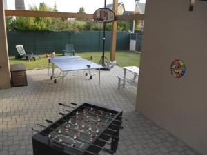 eine Tischtennisplatte im Hinterhof mit Basketballkorb in der Unterkunft Les Loges Du Ried - Studios & Appartements proche Europapark in Marckolsheim