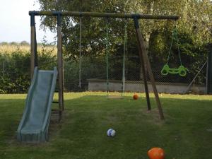 un parque infantil con un tobogán y una pelota en el césped en Les Loges Du Ried - Studios & Appartements proche Europapark, en Marckolsheim