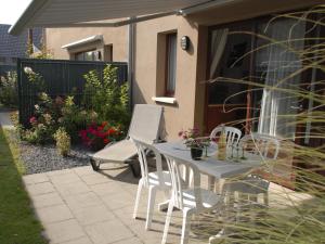 a white table and chairs on a patio at Les Loges Du Ried - Studios & Appartements proche Europapark in Marckolsheim