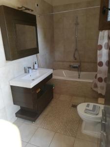 アスプロヴァルタにあるVilla Elvaのバスルーム(洗面台、トイレ、バスタブ付)