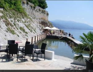 a table and chairs sitting next to a body of water at MANUELA in Senj