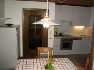 a kitchen with a table and a light at Haus Güatli in Gaschurn