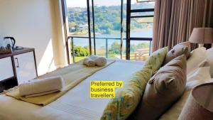 a baby laying on a bed in front of a window at Riverview Guesthouse East London in East London