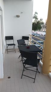 een patio met 2 stoelen en een tafel op een balkon bij Porto de Mós Apartment in Lagos