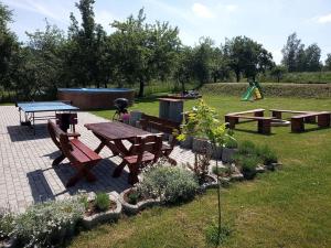 stół piknikowy i ławki w parku w obiekcie Holiday House Adrelot w mieście Heřmaničky