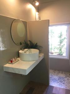 a bathroom with a sink and a mirror and a window at Saffron On The Sea Resort in Ko Chang