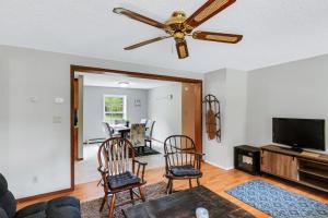 a living room with a ceiling fan and chairs at Chandler Hill Base Camp - Enjoy A Nature Getaway in this Rustic Home in the Mountains, 10 minutes from Sunday River Ski Mountain! home in Bethel