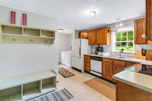 a kitchen with wooden cabinets and a white refrigerator at Chandler Hill Base Camp - Enjoy A Nature Getaway in this Rustic Home in the Mountains, 10 minutes from Sunday River Ski Mountain! home in Bethel +53 photos
