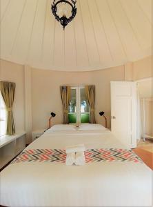 a bedroom with a large bed with two towels on it at Saffron On The Sea Resort in Ko Chang