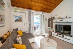 een woonkamer met een bank en een tv bij Indy's Beach Apartments in Dubrovnik