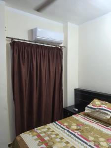 a bedroom with a bed and a brown curtain at Abeer Suites in Hurghada