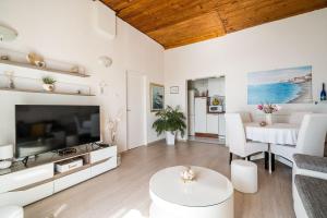 Televízia a/alebo spoločenská miestnosť v ubytovaní Indy's Beach Apartments
