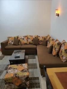 a living room with a brown couch and a table at Abeer Suites in Hurghada