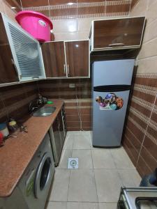 a small kitchen with a refrigerator with a picture on it at Abeer Suites in Hurghada