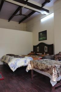 een kamer met 2 bedden en een tv aan de muur bij Mother Hostel in Varanasi