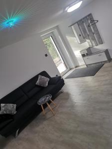 a living room with a black couch and a table at Ferienwohnung Annashome in Maxhütte-Haidhof
