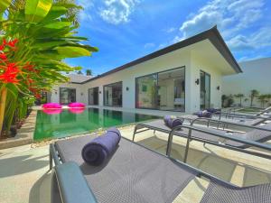 une villa avec une piscine et des chaises longues dans l'établissement VILLA JASMIN, à Koh Samui 