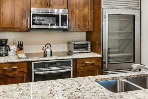a kitchen with stainless steel appliances and wooden cabinets at Townsend Place B-106 condo in Beaver Creek