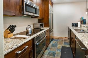 a kitchen with a sink and a microwave at Townsend Place B-106 condo in Beaver Creek +12 photos
