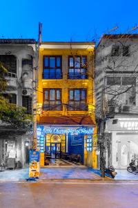 a yellow building with a sign on the front of it at Little Charm Hanoi Hostel - Homestay in Hanoi