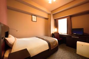 a hotel room with a bed and a television at Hotel Monte Hermana Sendai in Sendai