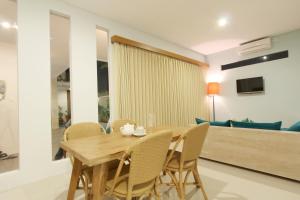a dining room with a wooden table and chairs at Apple Suite in Kerobokan
