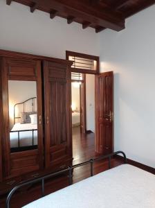 a bedroom with a bed and a wooden cabinet at A Mercé in Pobra do Caramiñal