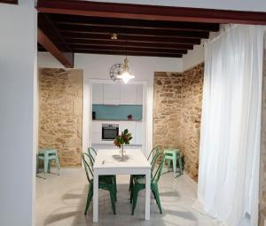 a dining room with a white table and green chairs at A Mercé in A Pobra do Caramiñal