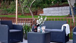 two blue wicker chairs and a table with flowers on it at A Mercé in A Pobra do Caramiñal