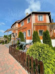 a statue of a dinosaur in front of a house at Hotel Lux Aquapark in Poltava