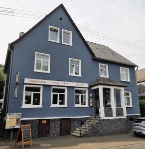 une maison bleue avec un panneau devant elle dans l'établissement Niederdreisbacher Hof, à Niederdreisbach