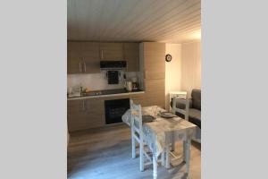 a kitchen and dining room with a table and chairs at Appartement ST Roch in Salins-les-Bains