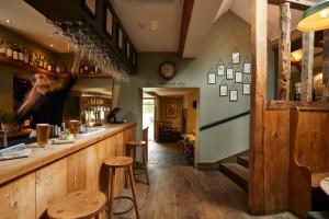 a man standing at a bar in a pub at The Kingham Plough in Kingham