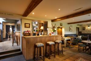 a bar in a restaurant with tables and chairs at The Kingham Plough in Kingham +29 photos