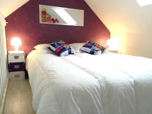 - une chambre avec un grand lit blanc et un mur rouge dans l'établissement Très joli duplex Port Crouesty Morbihan, à Arzon