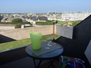 une table avec deux verres et un vase sur un balcon dans l'établissement Très joli duplex Port Crouesty Morbihan, à Arzon