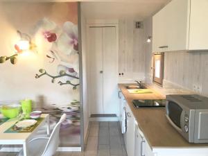 a kitchen with a counter with a microwave and a table at Studio Les Remparts de Kerjouanno in Arzon