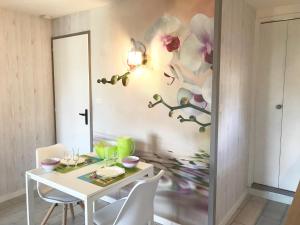 una sala da pranzo con tavolo e sedie bianchi di Studio Les Remparts de Kerjouanno ad Arzon