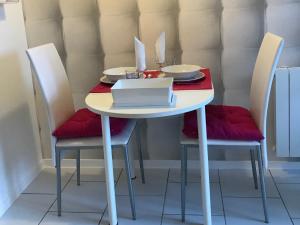 アルゾンにあるStudio Les Hameaux du Crouestyのテーブル(椅子2脚付)、白いテーブル(赤いクッション付)